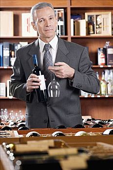 商务人士,拿着,葡萄酒瓶,葡萄酒杯