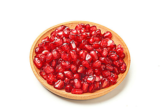 红石榴籽放在木盘里,纯白色背景
