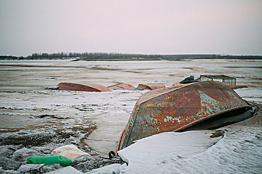 冬天冻结的江面上的废弃渡船
