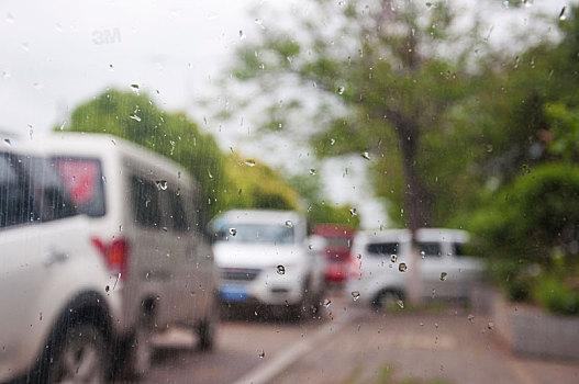 雨天玻璃上的雨滴以及模糊的车辆