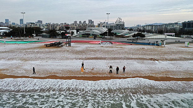 龙年瑞雪悄然而至,游客漫游海边赏雪打卡