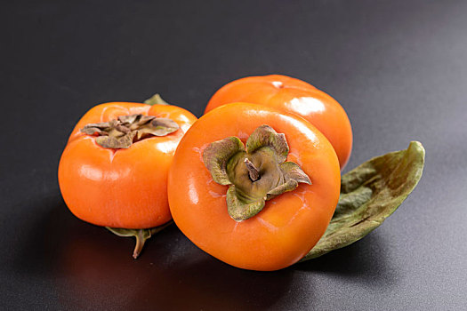 成熟的脆柿子摆放在桌面上