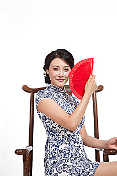 棚拍身穿中国传统服装的年轻女人坐中式椅
