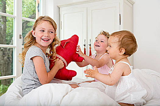 三个女孩,玩,床,毛绒玩具
