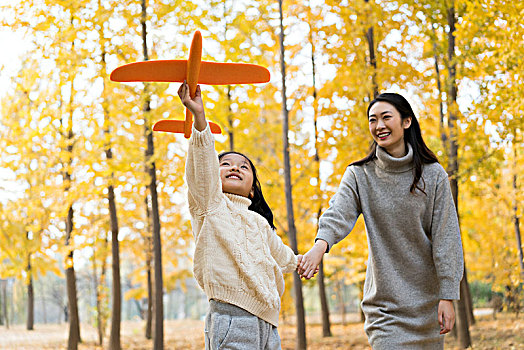 母女二人秋游漫步银杏林