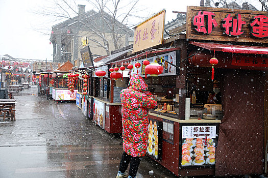 山东省日照市,游客踏雪逛美食街,感受不一样的元宵佳节