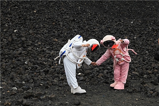 内蒙古火山口游客穿宇航服拿国旗拍照,宛若登陆外星球