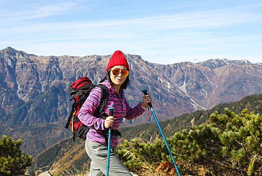 一个手拿登山杖在山上徒步的女性徒步旅行者