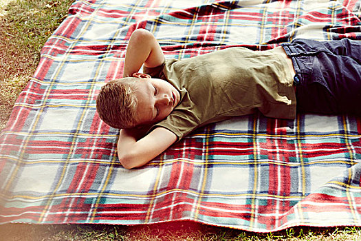俯拍,男孩,躺着,野餐毯,手放头后,看别处