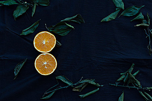 切开的橙子放在黑色麻布背景上