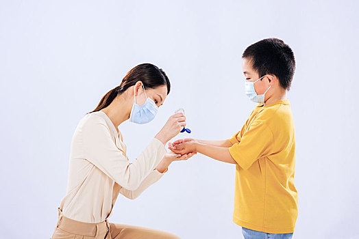 妈妈教小男孩使用免洗洗手液消毒