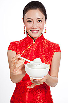 棚拍身穿中国传统服装的年轻女人吃元宵
