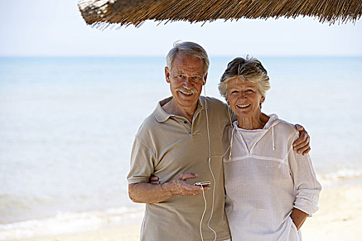 老年,夫妻,mp3播放器,音乐,一起,愉悦,搂抱,伞,海滩,海洋,养老金,退休,人,两个,老,老人,情侣,一对,退休老人,休闲服,夏天,现代,高兴