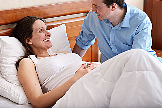 孕妇,卧,床上,丈夫,坐,旁侧