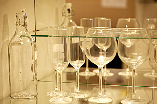 一排整齐的透明酒杯和一个透明的密封瓶