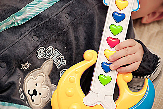 婴儿手里的吉他玩具特写