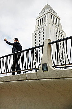 侧面视角,商务,男人,站立,人行道,抬手,洛杉矶,市政厅,加利福尼亚,美国