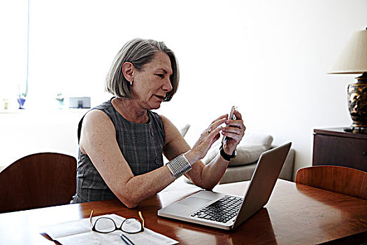 老人,职业女性,坐,书桌,笔记本电脑,正面,智能手机