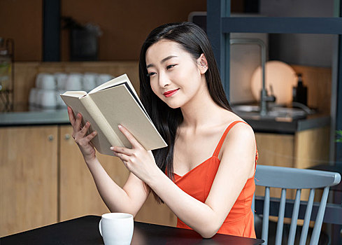年輕女子看咖啡店看書