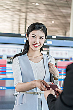 年轻商务女士在机场出示护照