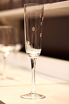 一个透明带装饰花纹的香槟酒杯