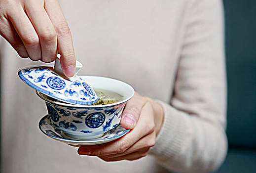 一个女人在喝盖碗茶