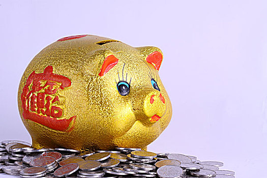 金色小猪存钱罐和散落在周围的硬币