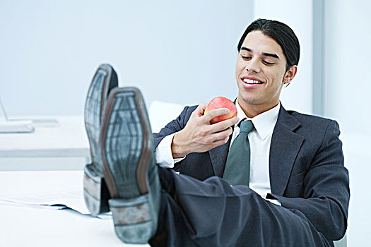 年轻,商务人士,坐,书桌,翘脚,吃,苹果