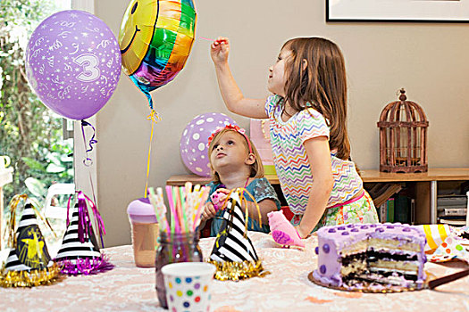 两个女孩,坐,生日派对,桌子,蛋糕,玩,气球