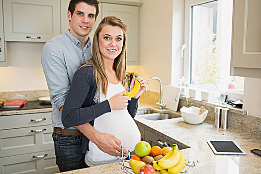 男人,搂抱,怀孕,妻子,拿着,香蕉,厨房