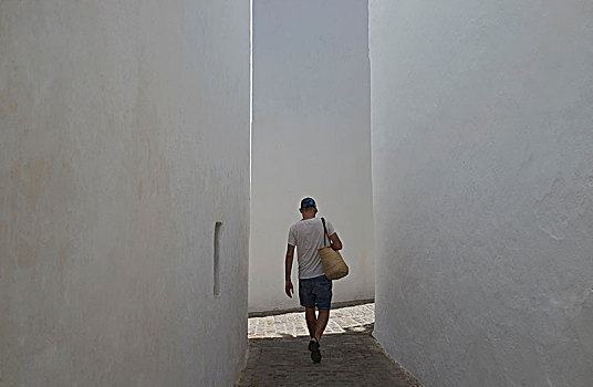 后视图,男青年,游客,漫步,狭窄,鹅卵石,街道,塔里,安达卢西亚,西班牙