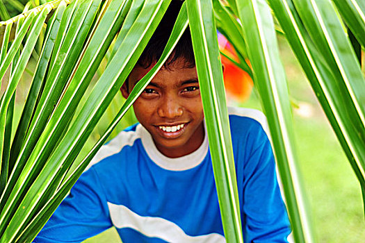 indonesia,sumatra,banda,aceh,portrait,of,young,boy,amid,green,dense,vegetation