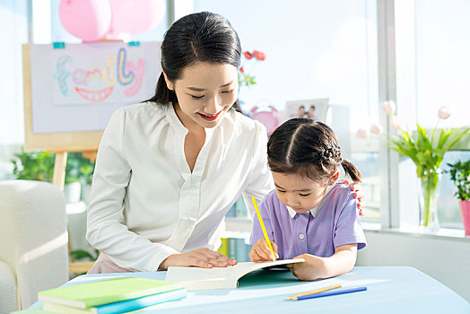 老師教小女孩讀書