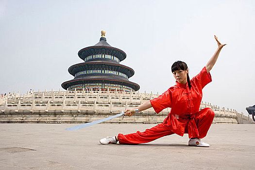 中国武术--一名女武术运动员在天坛祈年殿前练刀法