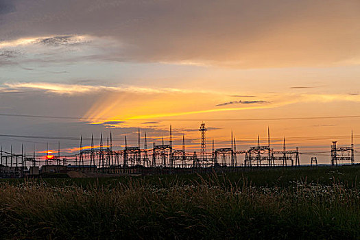 高压输电线路的一个工业区,对背景日出