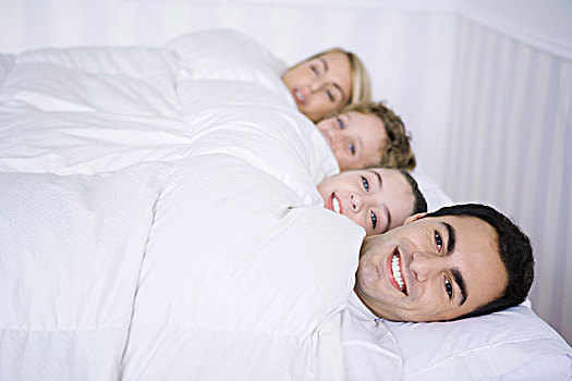 家庭,卧,一起,床上,鸭绒被,看镜头,微笑