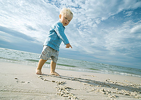 幼儿,站立,海滩,看镜头,指点,沙子