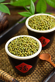 复古中国风格背景上放在两个福字水缸里的绿豆特写图片