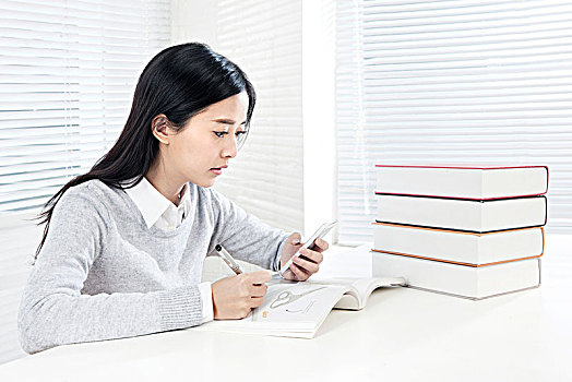 坐在桌子前学习的女大学生