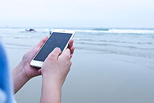女人海边使用智能手机