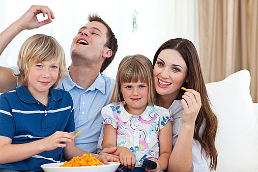 年轻家庭,吃,松脆食品,看电视