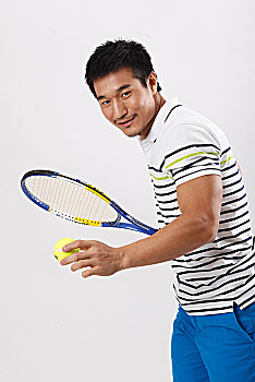 一个穿休闲装打网球的青年男士