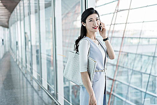 年輕商務(wù)女士在機(jī)場(chǎng)打電話