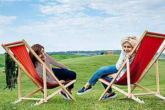 头像,两个,成熟,女性朋友,坐,红色,折叠躺椅,风景,托斯卡纳,意大利