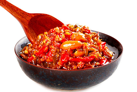 白底上一碗手工辣椒酱和勺子上挖着辣椒酱