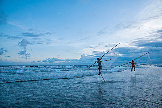 广西东兴京族万尾岛金滩渔民踩着高跷捕鱼捞虾
