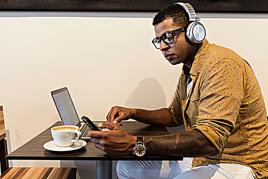 男青年,咖啡馆,戴着,耳机,使用笔记本,智能手机