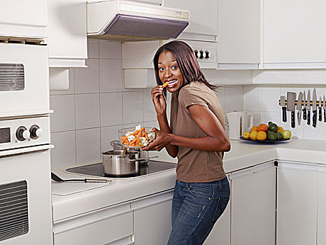 女人吃,而,烹饪,在厨房,微笑的,肖像,侧视图