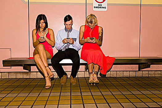 三个,年轻人,朋友,发短信,坐,地铁站