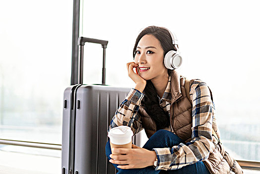 年轻女子在机场听音乐